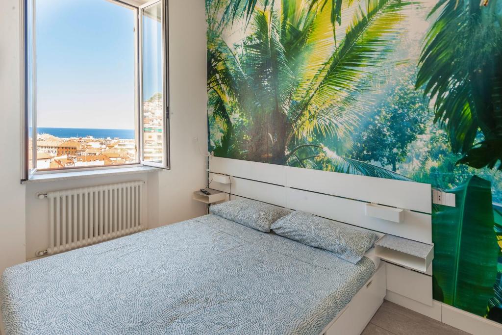 una camera con un letto e un grande dipinto sul muro di CasaBaltó a Sanremo