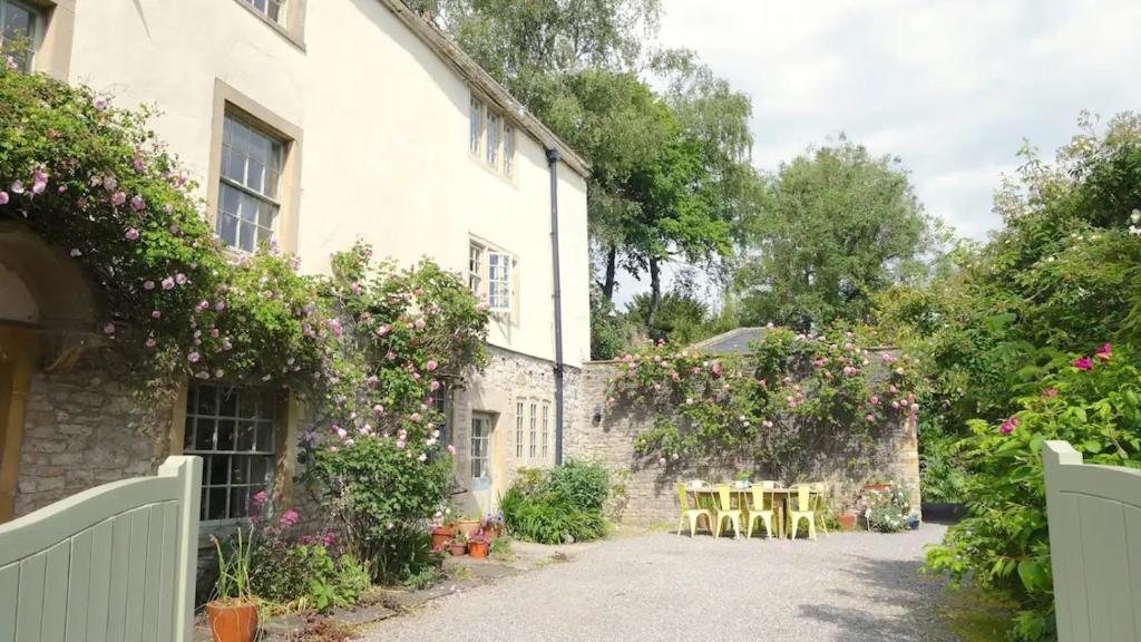 dom z krzesłami i kwiatami na boku w obiekcie Lovely property in the heart of Somerset, sleeps 9 w mieście Shepton Mallet