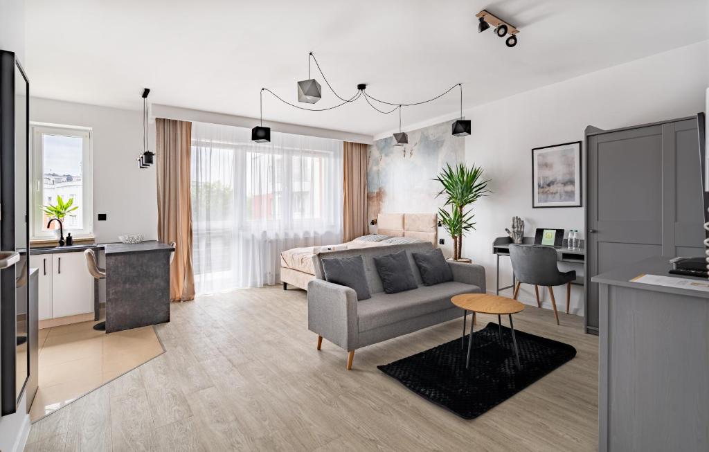 uma sala de estar com uma cama, um sofá e uma mesa em Grelewicz Apartments- MyWay em Toruń