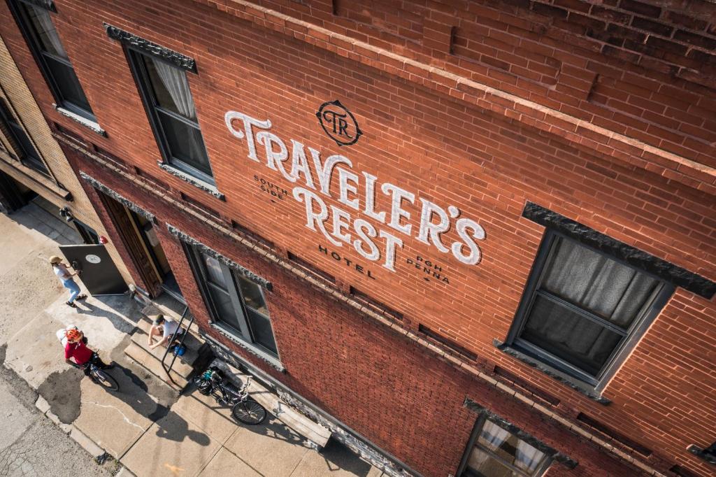 a red brick building with a sign that reads players resist at Traveler's Rest Hotel in Pittsburgh