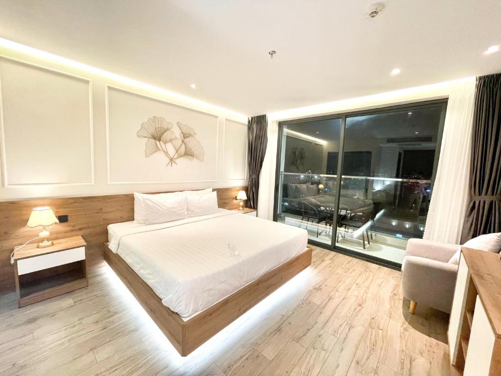 sypialnia z białym łóżkiem i dużym oknem w obiekcie White House Condotel Phú Yên w mieście Tuy Hòa