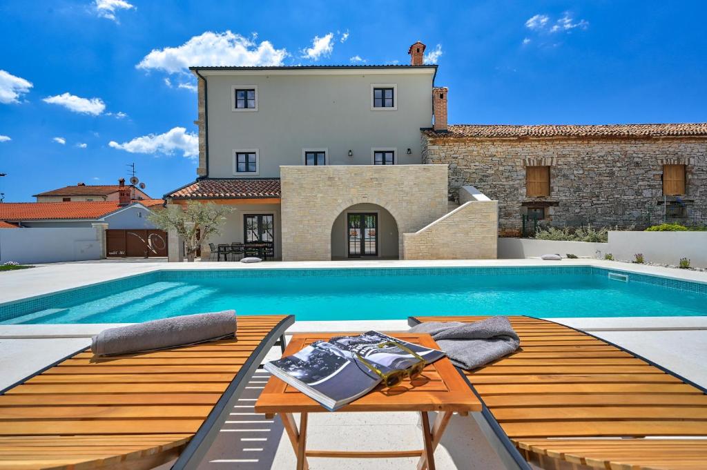 a villa with a swimming pool and a house at Villa Vitassi in Pula