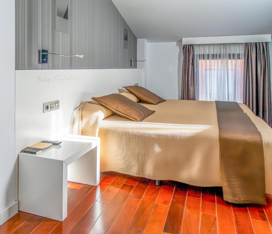 a bedroom with a large bed and a table at Hotel Apolonia Soria in Soria