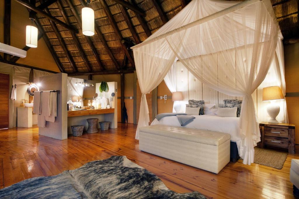 - une chambre avec un lit à baldaquin dans l'établissement Bush Lodge – Amakhala Game Reserve, à Réserve animalière d'Amakhala