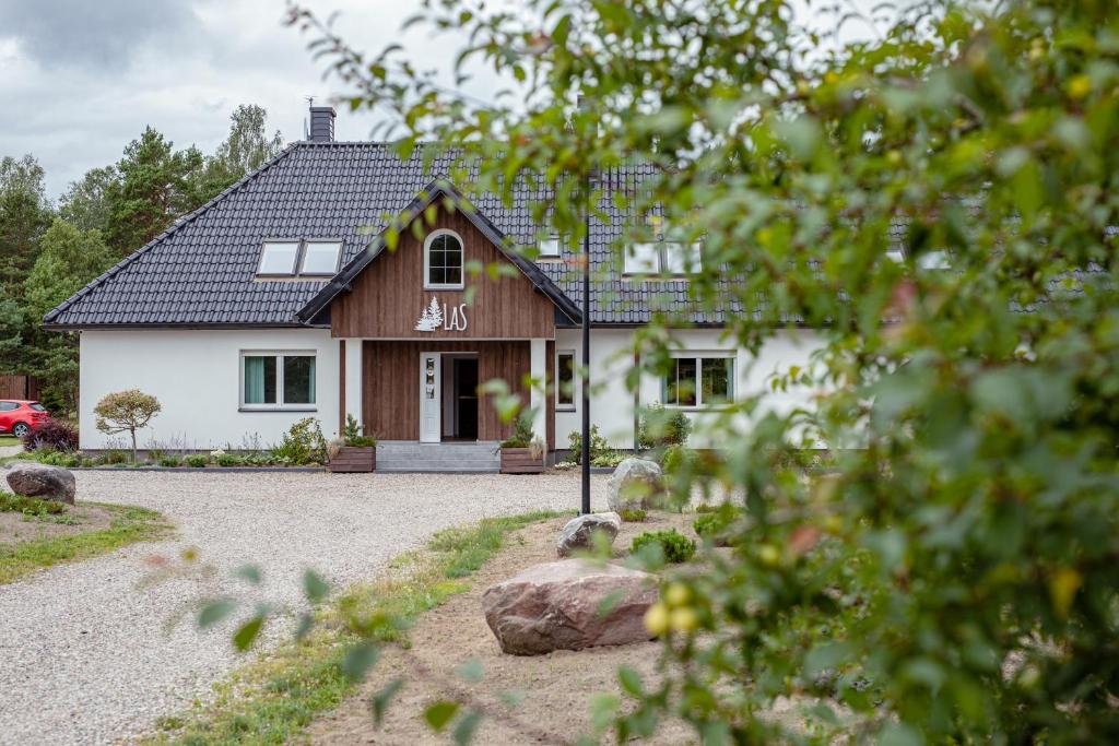 a house with a gravel driveway in front of it at LAS APARTAMENTY in Borowy Młyn