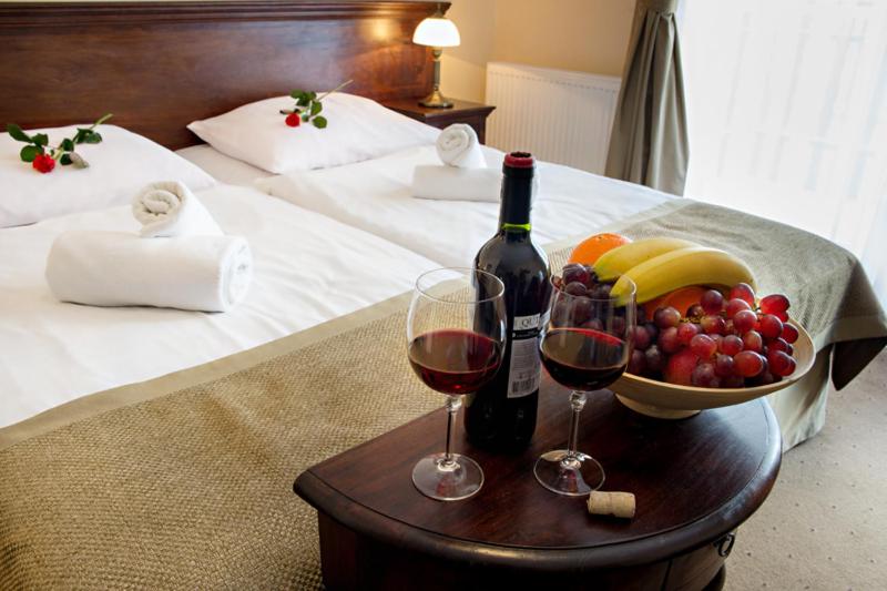 a table with two glasses of wine and a bowl of fruit at Hotel Carmen in Karpacz