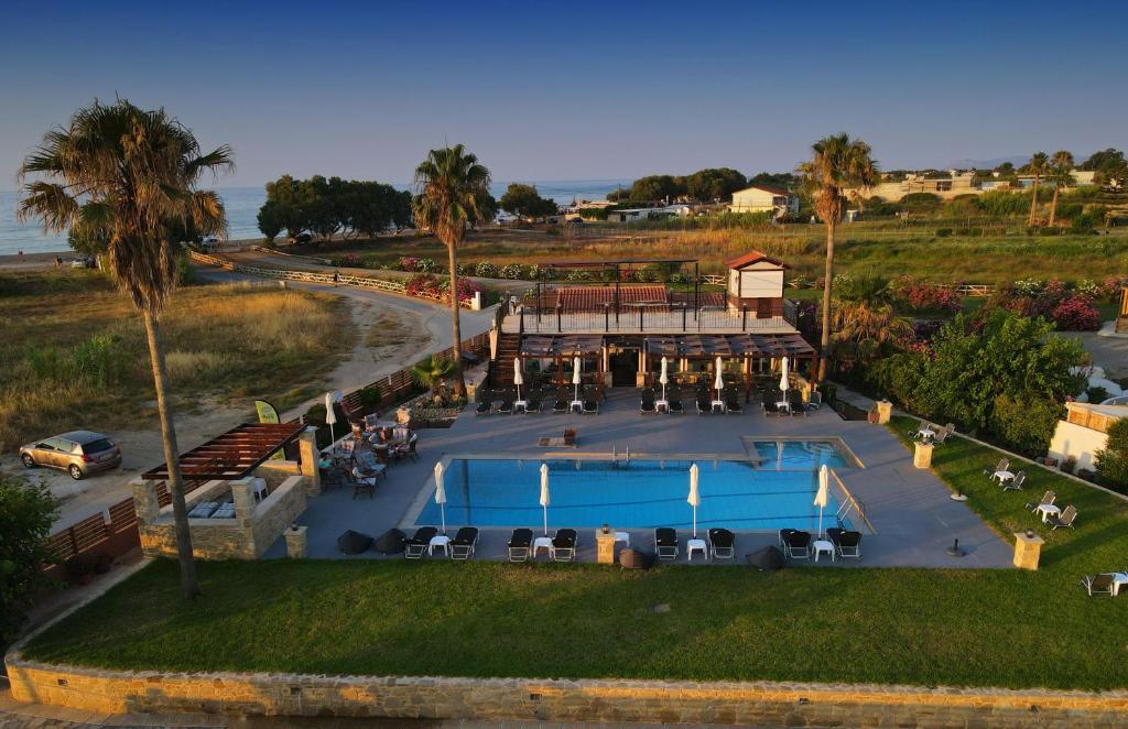 - une vue aérienne sur un complexe avec une piscine et des palmiers dans l'établissement Odos Oneiron Tavronitis Bay, à Tavronítis