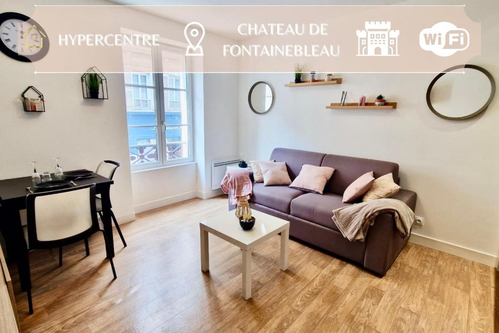 uma sala de estar com um sofá e uma mesa em Appart'Hôtel - Le Sweet Cosy em Fontainebleau