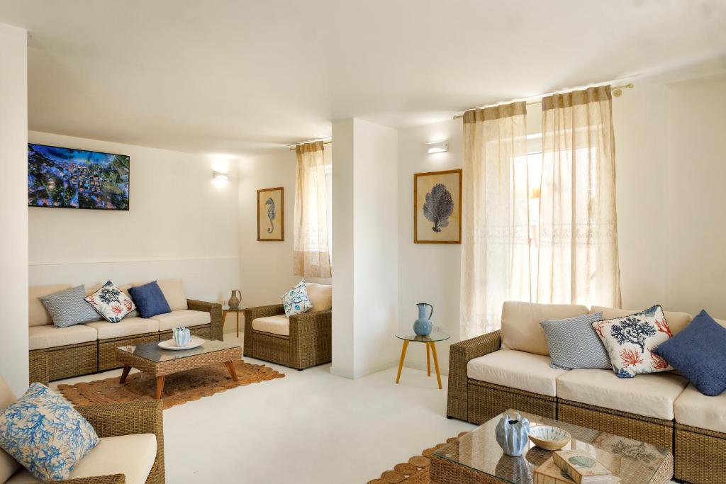 un soggiorno con due divani e un tavolo di Mercury Beach Hotel a SantʼAntìoco