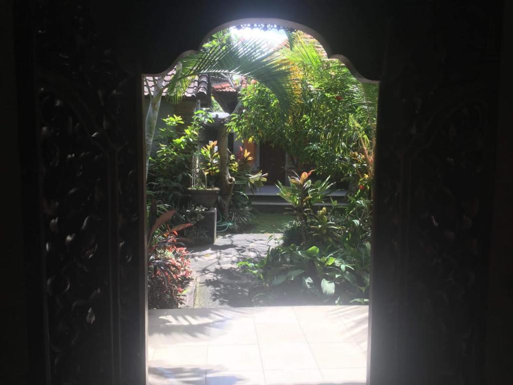 an entrance to a garden through an archway at Family Guest House in Ubud