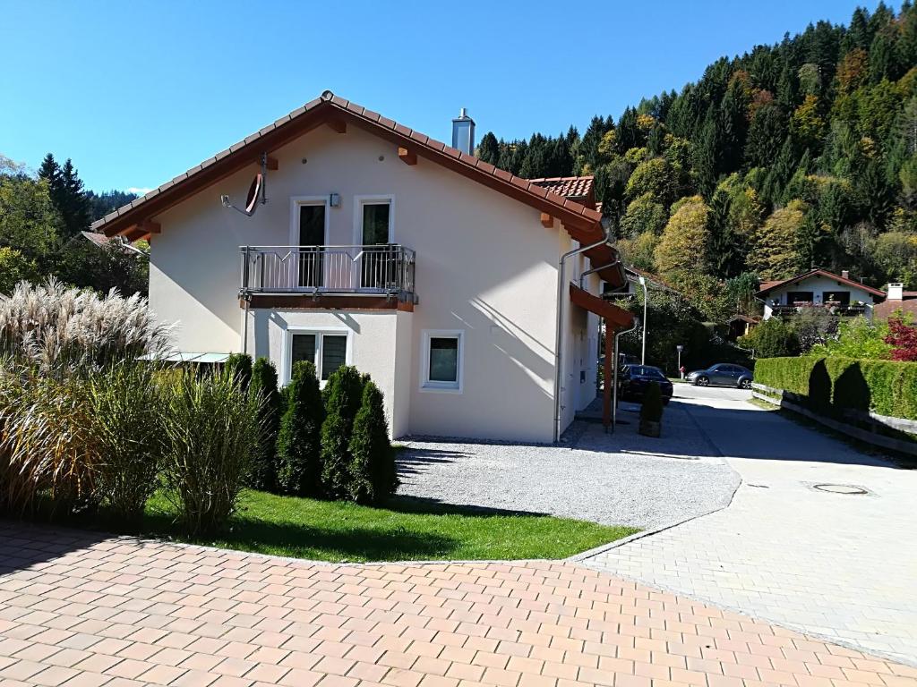uma casa branca com uma varanda e uma entrada em Ferienwohnungen Bergidyll em Sachrang