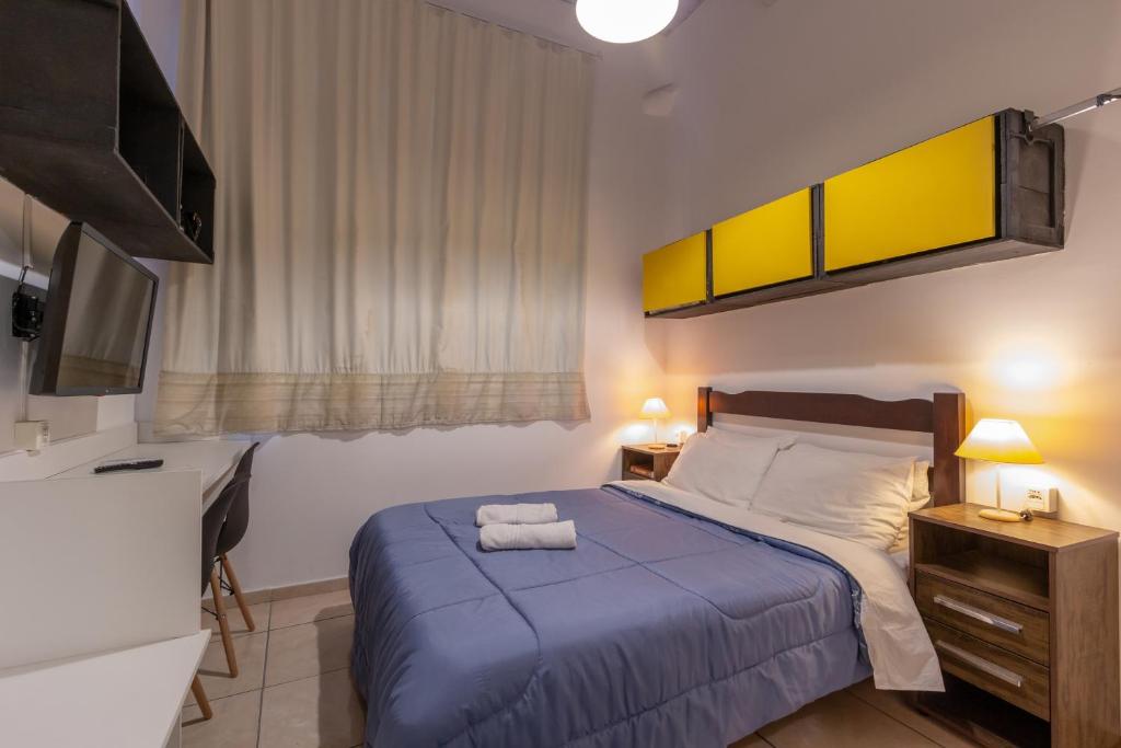 1 dormitorio con 1 cama con manta azul en BH Studios Hotel Brás, en São Paulo