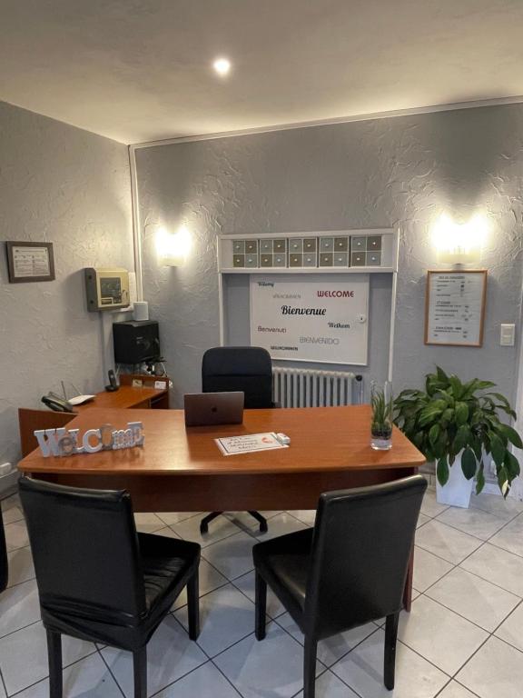 an office with a large wooden table and chairs at Hôtel les Platanes in Villeneuve-sur-Lot