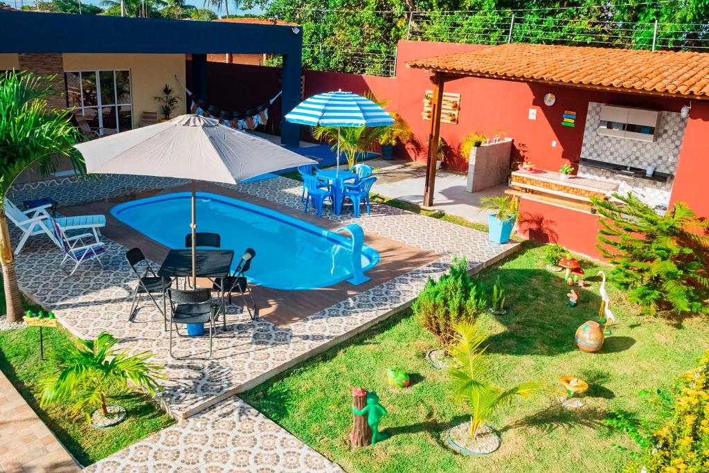 a backyard with a swimming pool and a house at Casa c lazer à 750m da Barra de Santo Antônio AL in Barra de Santo Antônio