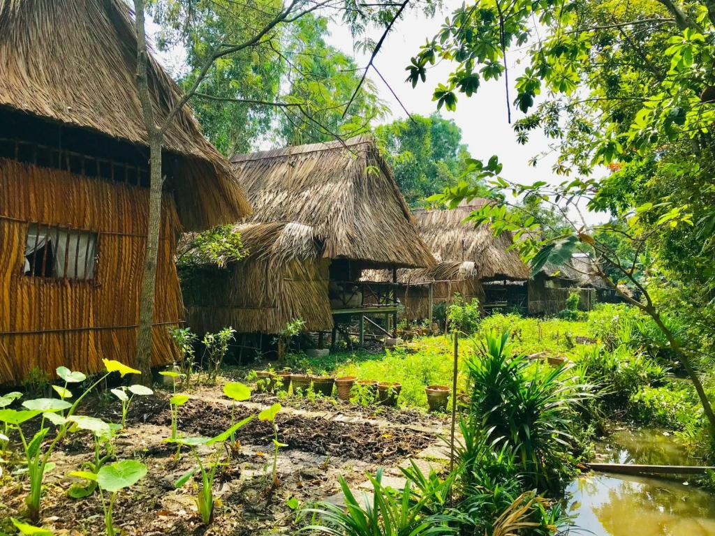 un pueblo con cabañas de paja en la selva en Saigon Garden Homestay, en Ho Chi Minh