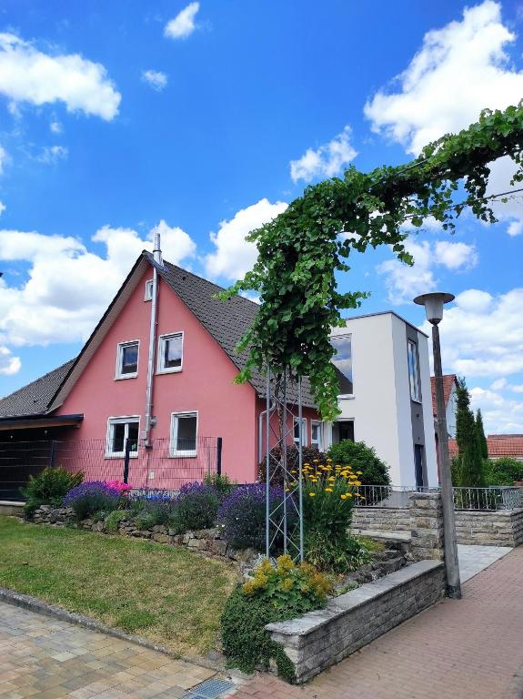 a pink house with flowers in front of it at Ferienwohnung an der Klinge in Wiesenbronn