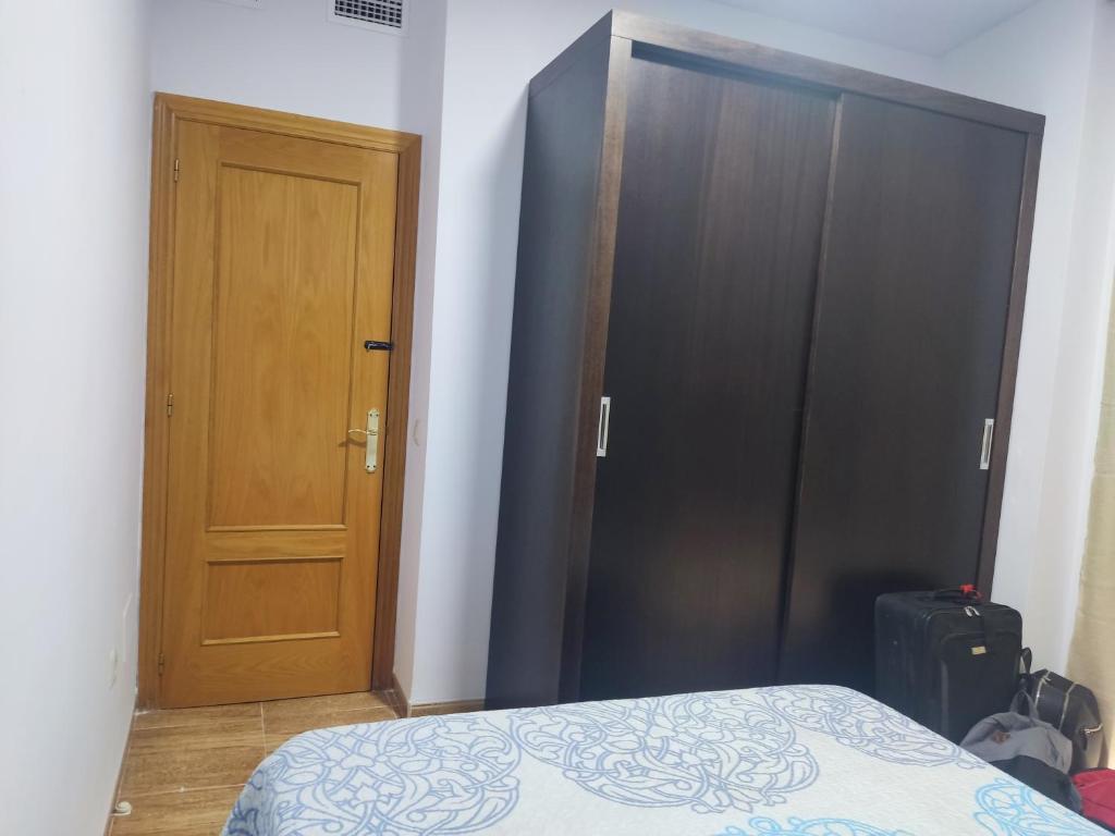 um quarto com uma cama e uma porta de madeira em Apartamentos el rebalaje III em Roquetas de Mar