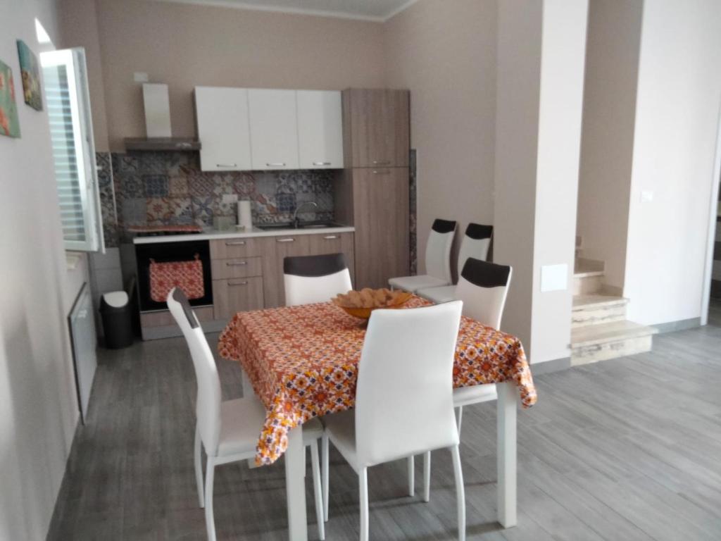 cocina y comedor con mesa y sillas en Casa Vacanza al mare, en Isola di Capo Rizzuto