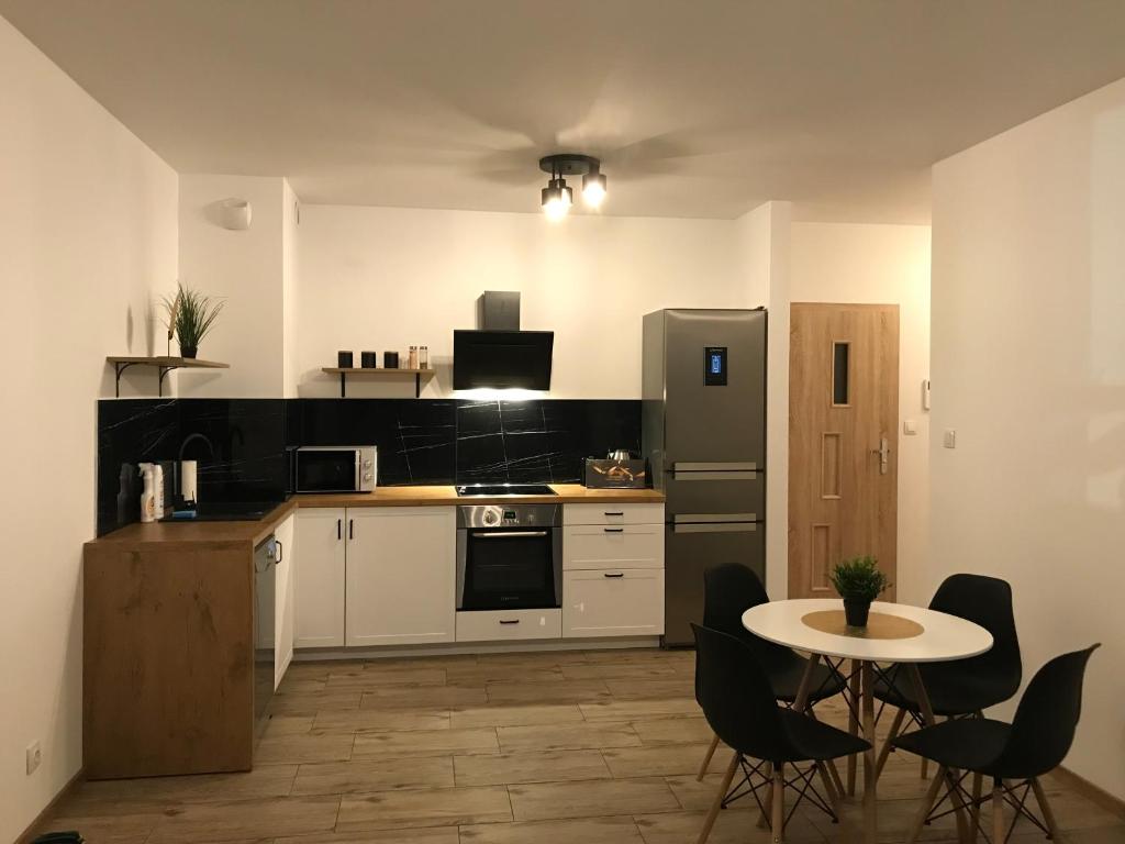 kuchnia ze stołem, krzesłami i lodówką w obiekcie Apartament Aquatower w Redzie