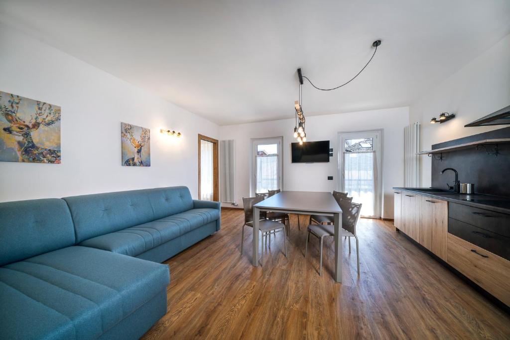 uma sala de estar com um sofá azul e uma mesa em Cauriol Suites 2.3 em Cavalese