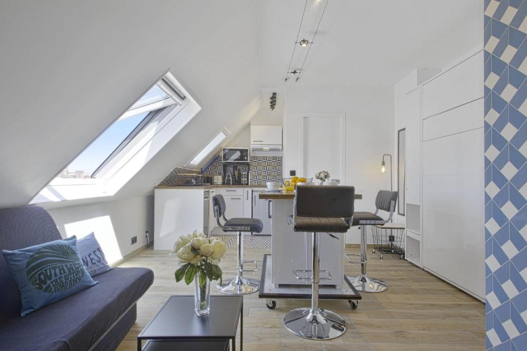 een woonkamer met een bank en een keuken bij Beautiful modern studio with a view on the ocean - Biarritz - Welkeys in Biarritz