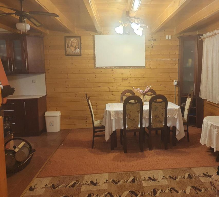 a dining room with a table and four chairs at Dom Wypoczynkowy Windmill in Kopalino