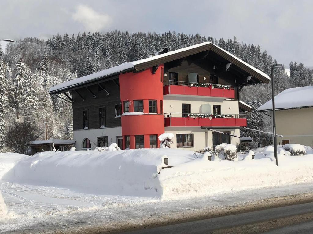 レオガングにあるAppartementhaus Bergblickの雪中の赤黒の建物