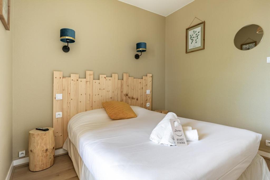 a bedroom with a bed with white sheets and blue lights at Hotel Les Vieux Acacias in Queyrac