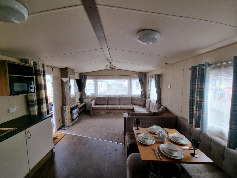 a living room with a couch and a table in a caravan at Willow-Static Caravan on Holiday Park near Margate, Kent in Kent