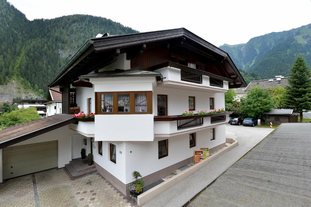 una casa blanca con techo negro en Ferienwohnung Fankhauser, en Mayrhofen