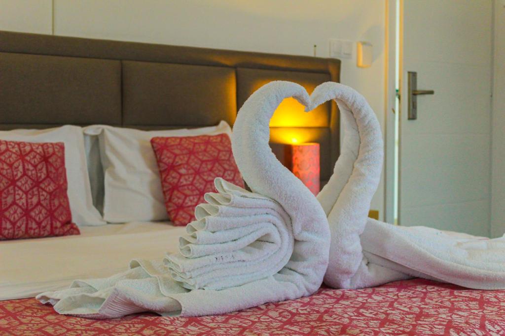 two swans made out of towels on a bed at Oaza Mira Hotel & Resort-فندق ومنتجع واحة الهدوء in Vlasic