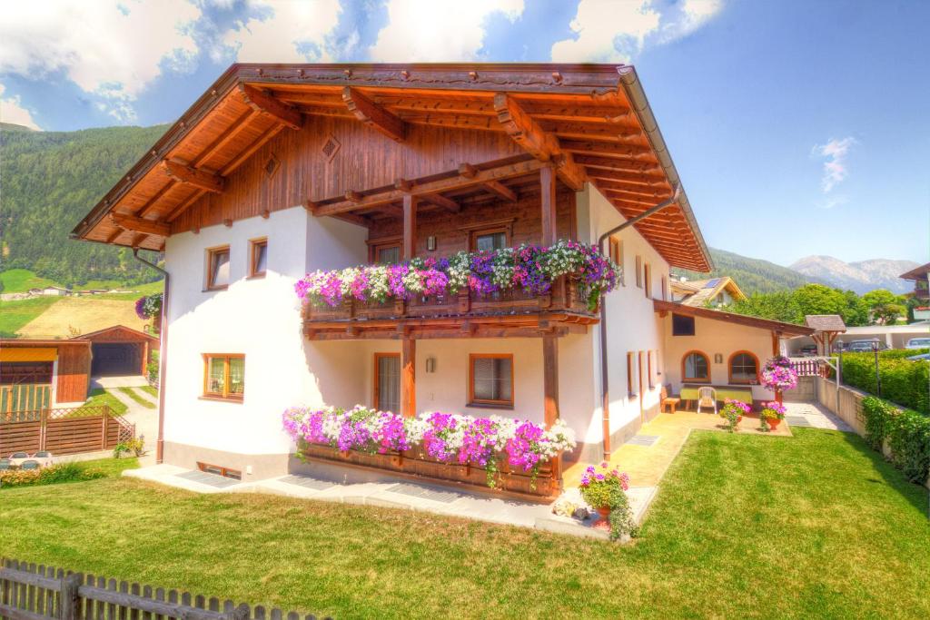 a house with a balcony with flowers at Haus Elisabeth in Neustift im Stubaital