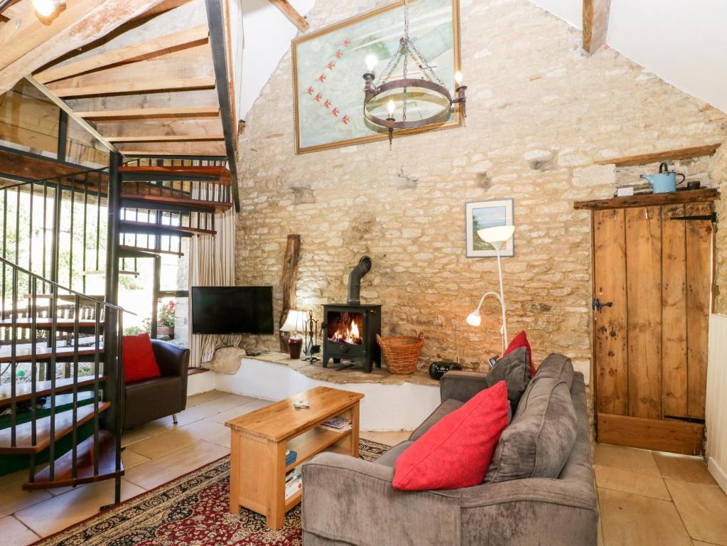 a living room with a couch and a fireplace at Tump Cottage in Nympsfield