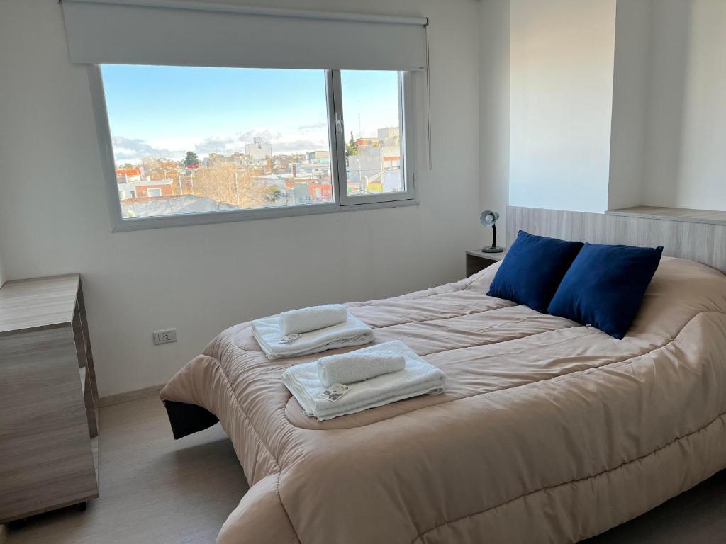 a bedroom with a large bed with towels on it at APART trelew 5 in Trelew