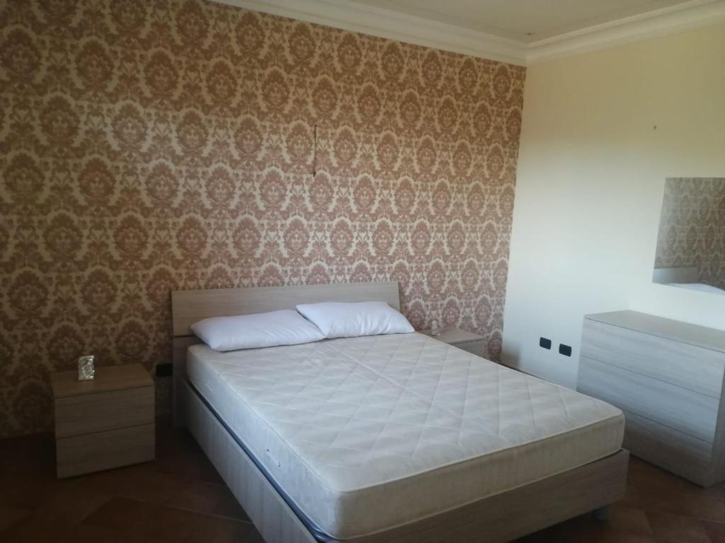 um quarto com uma cama e uma parede em Villa Di Caro em Ravanusa