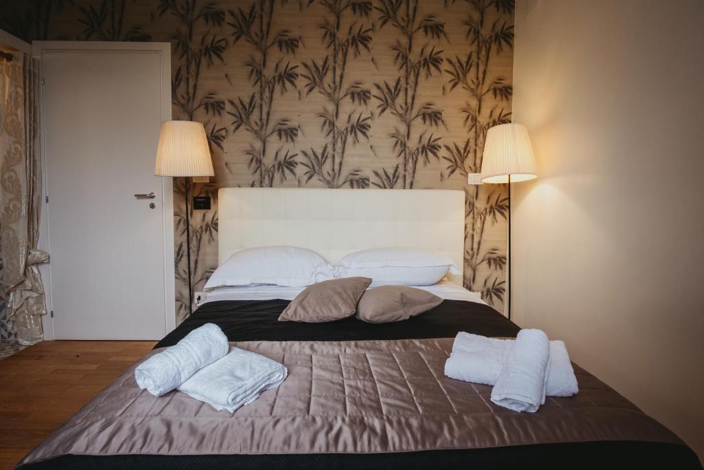 a large bed with two pillows and towels on it at SUITE COLOSSEO in Rome