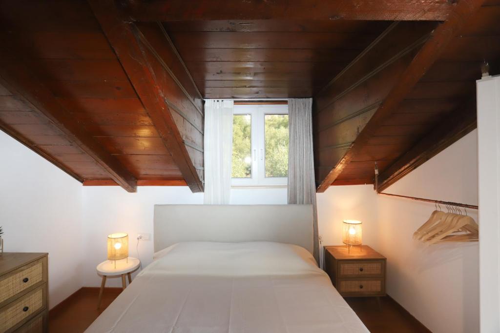 - une chambre avec un grand lit et deux lampes dans l'établissement Eleni's Guesthouse, à Paleokastritsa