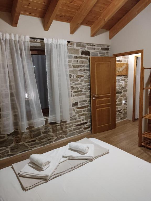 1 dormitorio con cama y pared de ladrillo en dolihis gi "loupastra"kampos ikaria, en Evdilos