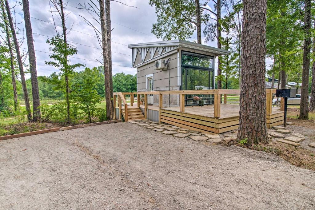 a home for sale in the woods with a wrap around porch at Chic Tiny Home Retreat about 2 Mi to MSU Campus! in Starkville