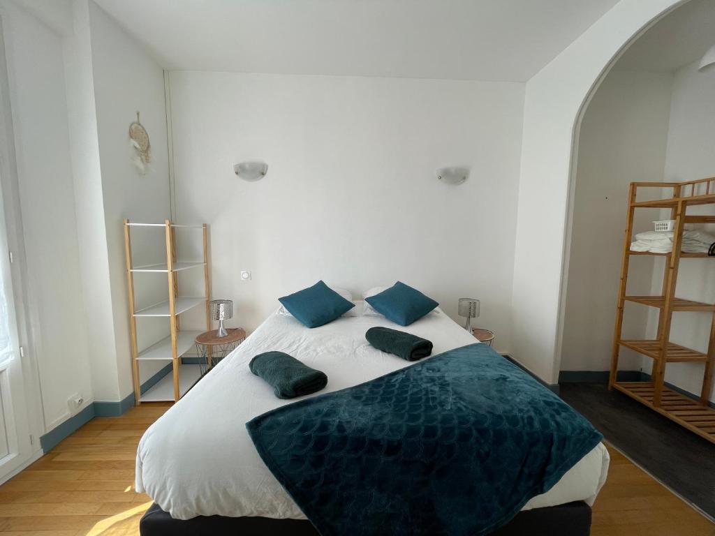 a bedroom with a large bed with blue pillows at ATLANTIS in Saint-Nazaire