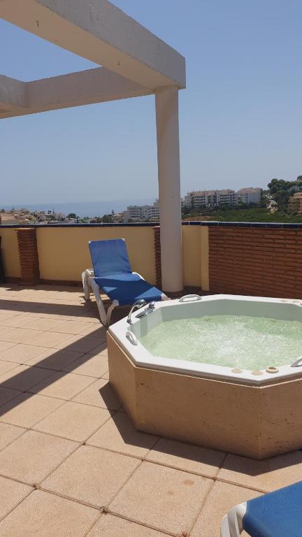 a hot tub on the roof of a building with a chair at Green hills in La Cala de Mijas