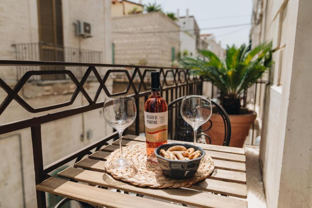 Una botella de vino y dos copas en una mesa. en AURA, en Terlizzi