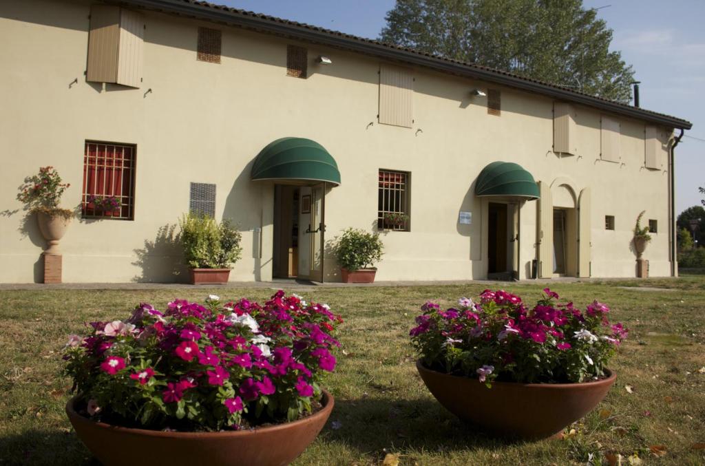 two large pots of flowers in front of a building at Fondo Riso in Faenza