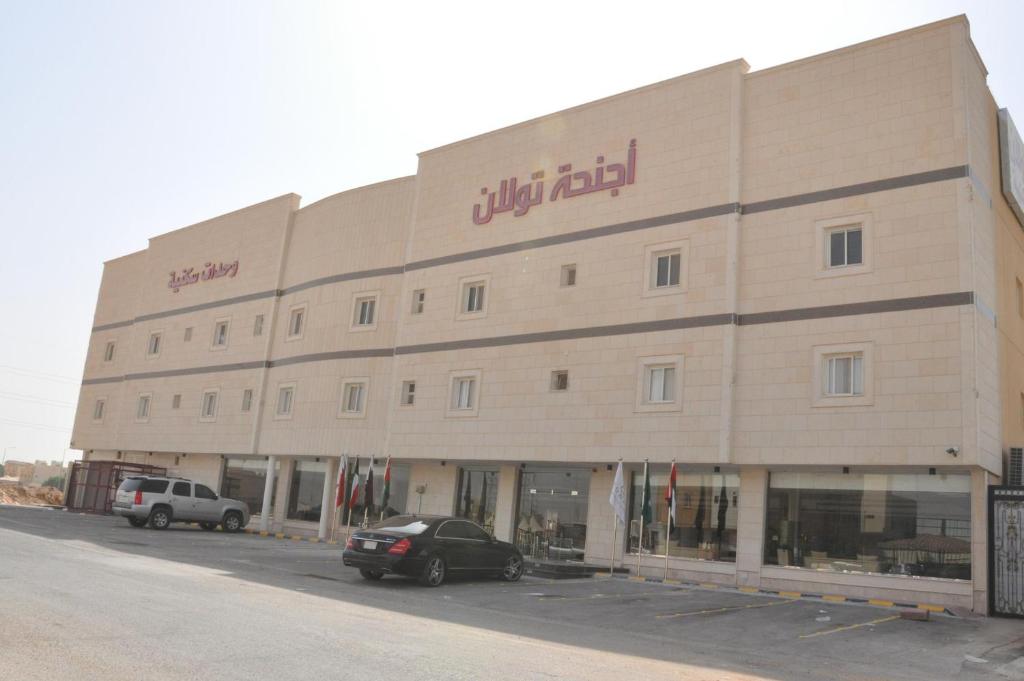 un gran edificio con un coche aparcado delante de él en Towlan Hotel Suites 1, en Riad