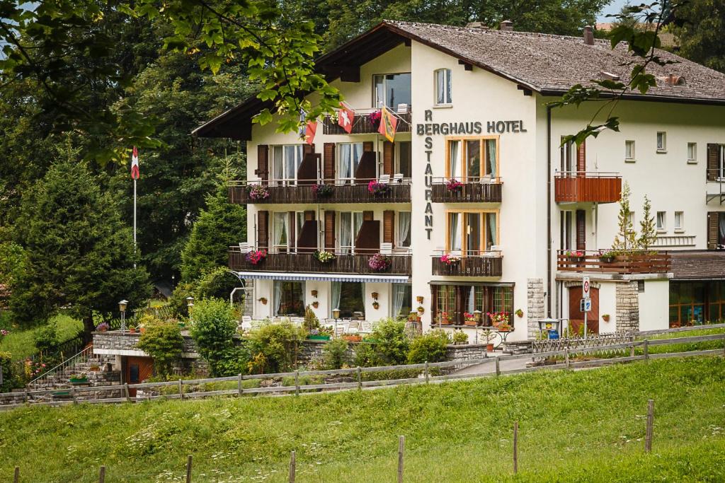 - un grand bâtiment blanc avec un panneau dans l'établissement Hotel Berghaus, à Wengen