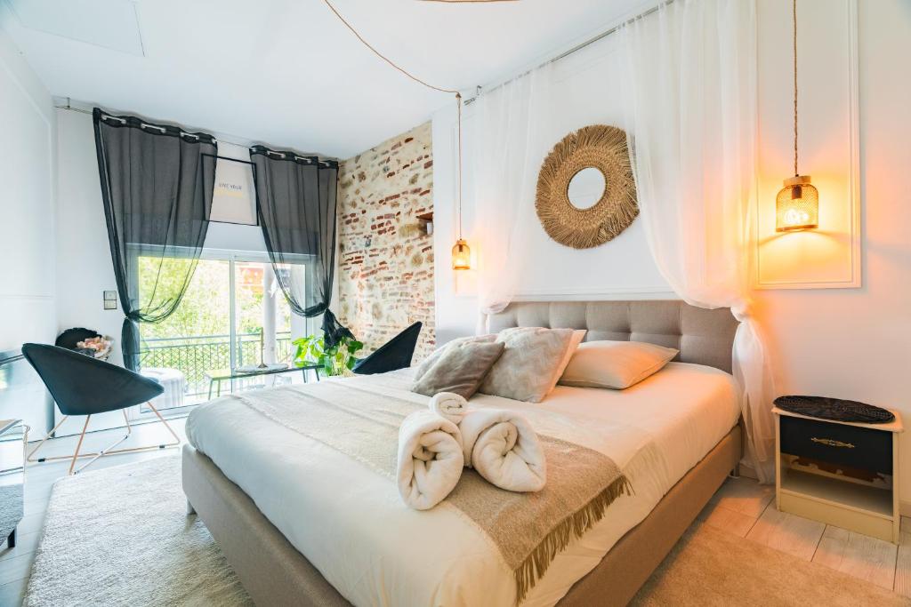 1 dormitorio con 1 cama con 2 toallas en Chambre unique Lovya, avec Jacuzzi en hypercentre en Villeneuve-sur-Lot
