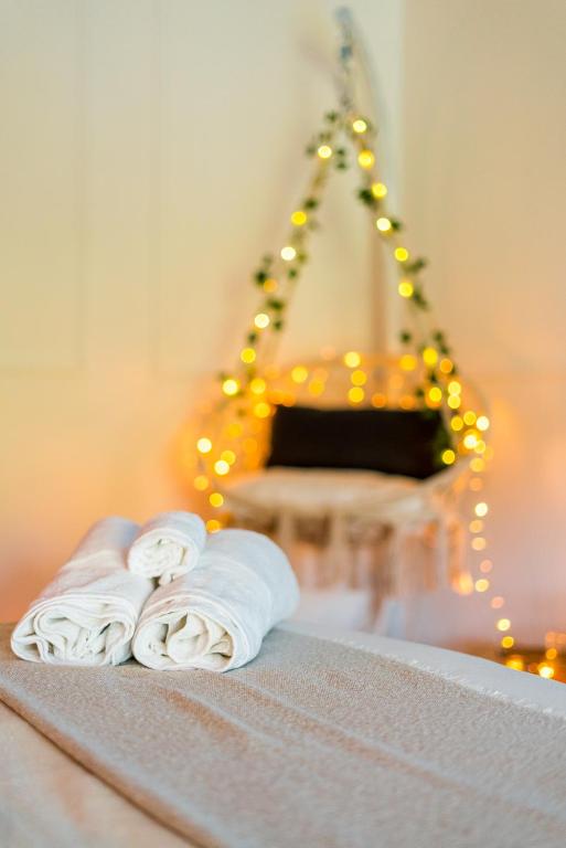 two towels on a bed in front of a christmas tree at Chambre unique Lovya, avec Jacuzzi en hypercentre in Villeneuve-sur-Lot