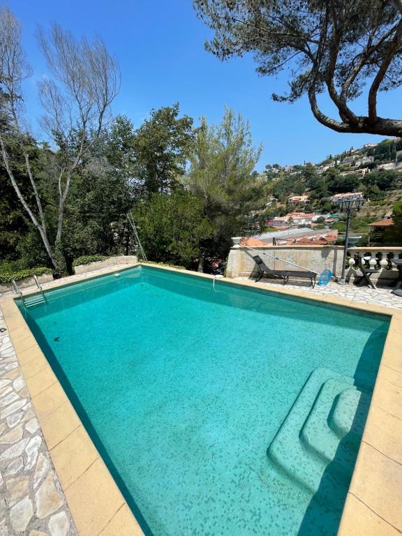 une grande piscine d'eau bleue dans l'établissement appartement bas de villa avec piscine privée partagée proche bord de mer, à Cagnes-sur-Mer