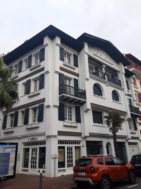 a white building with a car parked in front of it at Résidence Albina centre Hendaye Plage in Hendaye