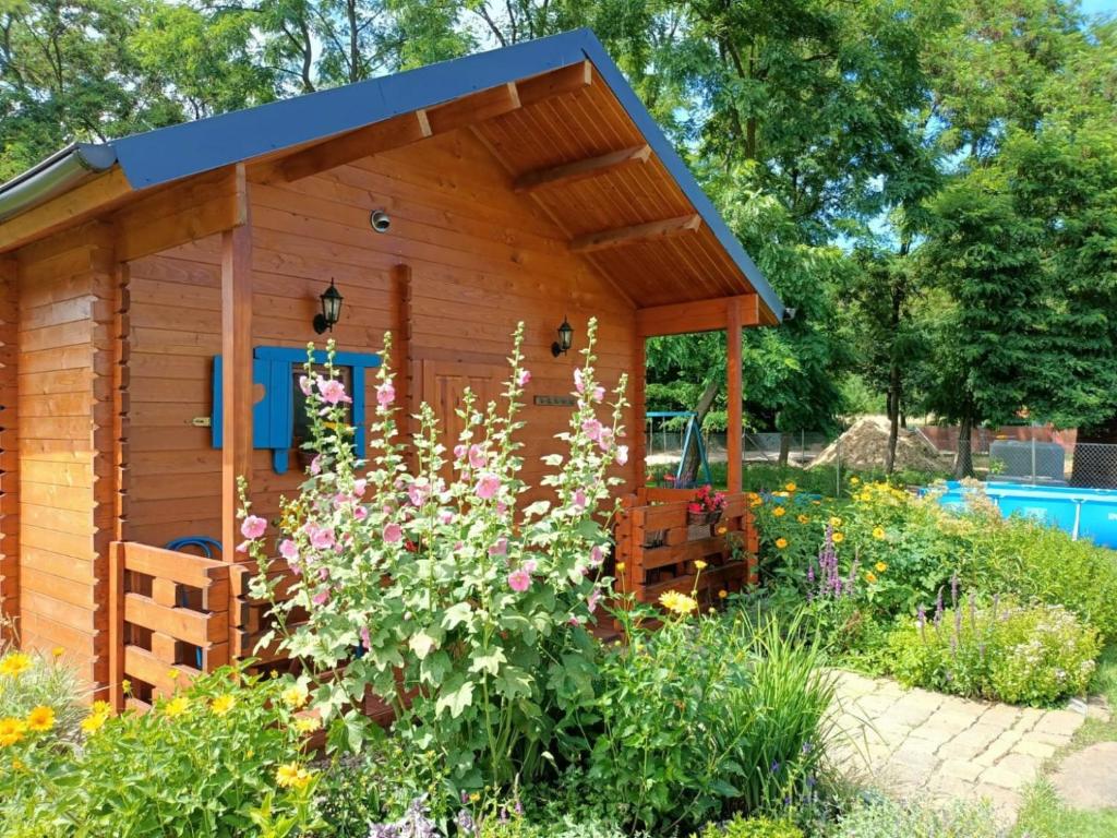 a wooden shed in a garden with flowers at Smocze Ranczo in Ośno Lubuskie